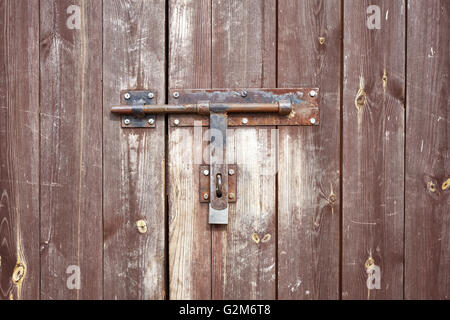 Vecchia cerniera a occhiello metallico sul vecchio vintage porta di legno. Foto Stock
