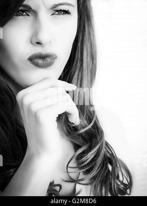 Ritratto in bianco e nero di un teso pensieroso giovane donna che guarda pensieroso e interessati Foto Stock