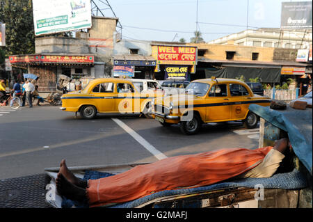 INDIA Westbengal Calcutta Kolkata, persone senza fissa dimora a Elgin Road e Ambasciatore Taxi / INDIEN Westbengalen Megacity Kalkutta, obdachlose Menschen schlafen am Strassenrand der Elgin Road, im Hintergrund fahren gelbe Ambasciatore Taxi Foto Stock