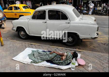 INDIA Westbengal, Calcutta, senzatetto dormire sulla strada, parcheggio HM Ambassador auto Foto Stock