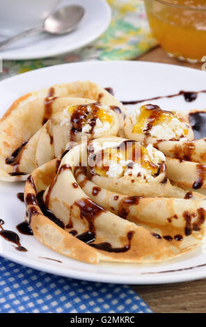 Pancake piegato nella forma di una lumaca per la ricotta con il cioccolato Foto Stock