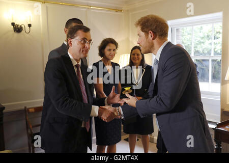Il principe Harry (destra) con le mani su un Invictus Games medaglia d'oro conquistata da Elizabeth Segna per il consulente intensivist Dr Alain Vuylsteke, originariamente provenienti dal Belgio e gli altri membri del Papworth Hospital Medical team che ha contribuito a salvare il servicewoman la vita, come essi visitare Kensington Palace a Londra. Foto Stock