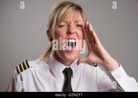 OFFICER URLA UN ORDINE Ritratto di una donna uniformata officer gridando e ordine Foto Stock