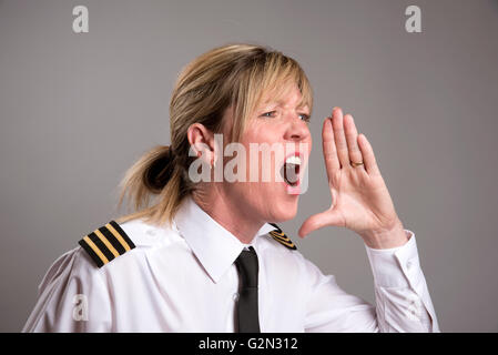 OFFICER URLA UN ORDINE Ritratto di una donna uniformata officer gridando e ordine Foto Stock