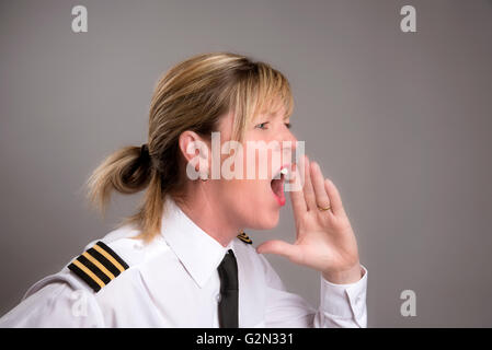 OFFICER URLA UN ORDINE Ritratto di una donna uniformata officer gridando e ordine Foto Stock