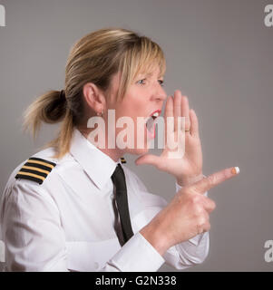 OFFICER URLA UN ORDINE Ritratto di una donna uniformata officer gridando e ordine Foto Stock