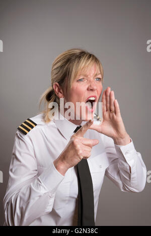 OFFICER URLA UN ORDINE Ritratto di una donna uniformata officer gridando e ordine Foto Stock