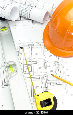 Piani di costruzione con casco di sicurezza e strumenti di misurazione Foto Stock
