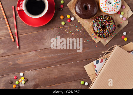 Le ciambelle e caffè sul tavolo di legno. Vista da sopra con lo spazio di copia Foto Stock