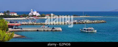 Vista distante di Skala il porto e la spiaggia e la chiesa, nell'isola di Agistri un'ora di viaggio dal Pireo, nel golfo Saronico, Grecia Foto Stock