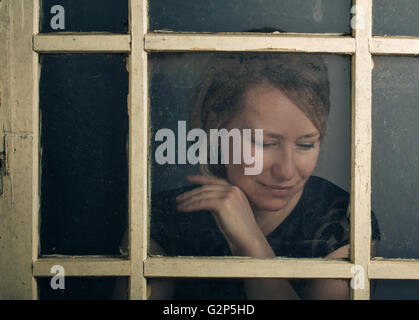 Ritratto di un blone donna adulta con la vecchia finestra rustico Foto Stock