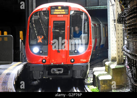 Di fronte al treno della metropolitana Circle Line di Londra e all'autista si oscurava la faccia che uscendo dal tunnel che entrava nella piattaforma della stazione ferroviaria Inghilterra UK Foto Stock