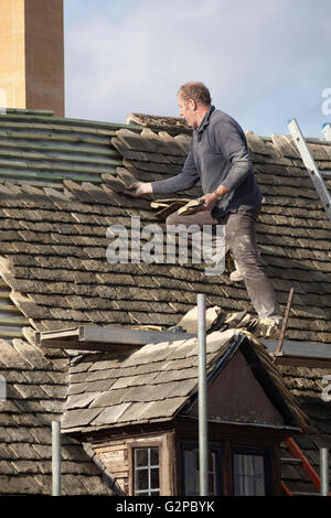 Copritetti posa di tegole del tetto su Cotswold cottage in pietra, Chipping Campden, Cotswolds, Gloucestershire, England, Regno Unito Foto Stock