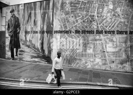 Un giovane africano adulto di portare il suo passato di shopping un gigante di accaparramento su Castle Street. Belfast. L'Irlanda del Nord. Regno Unito Foto Stock