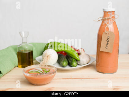 Il Gazpacho andaluso con ingredienti su una tavola di legno di pino di sfondo Foto Stock