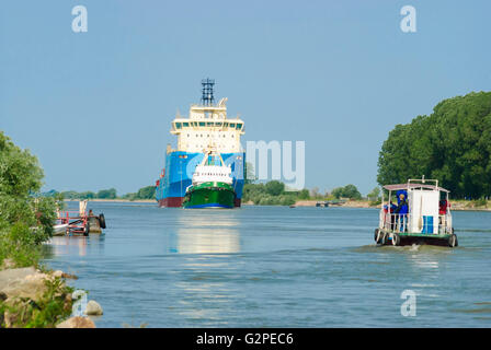 Nave turistica in sulina ramo del Danubio nel Delta del Danubio incontra la nave cargo con rimorchiatore, Romania, Dobrogea, Dobruja, D Foto Stock