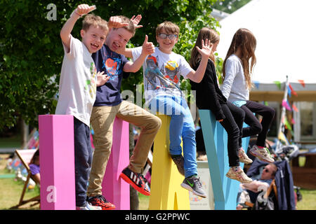 Festival di fieno, Wales, Regno Unito - Giugno 2016 - Il sole torna al Festival di fieno e i bambini godono della possibilità di giocare su il gigante di segno di fieno sui prati del Festival. Foto Stock