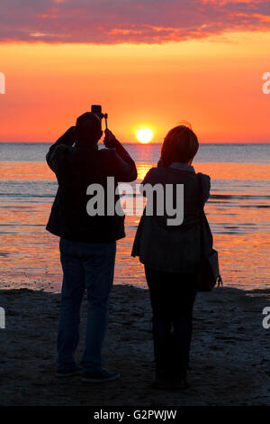 Southport, Merseyside, Regno Unito. 02Giugno, 2016. Una coppia sposi in luna di miele prendere selfies contro il sole di setting al largo di Southport nel Merseyside. La innamorati dell Europa orientale ha deciso di prenotare la propria vacanza nel Regno Unito prima del prossimo referendum UE. Credito: Cernan Elias/Alamy Live News Foto Stock