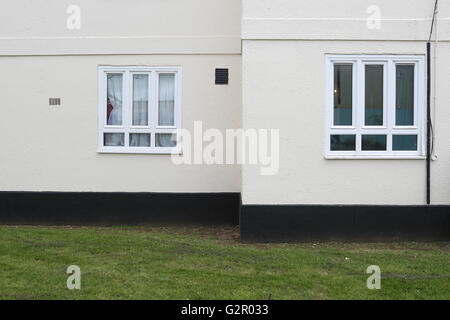 Dettaglio del bordo di un blocco di appartamenti - bianco, nero e pareti UPVC windows, erba, nella zona di Hammersmith London Foto Stock