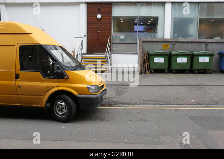 Giallo Ford Transit van parcheggiato al di fuori dei locali commerciali, cassonetti nella zona di Hammersmith London Foto Stock