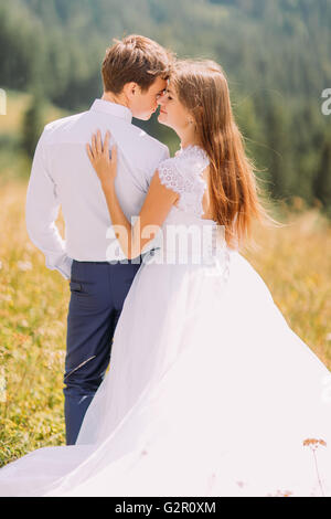 Close-up di bella coppia azienda ogni altro all'aperto a giornata soleggiata con la foresta come sfondo Foto Stock