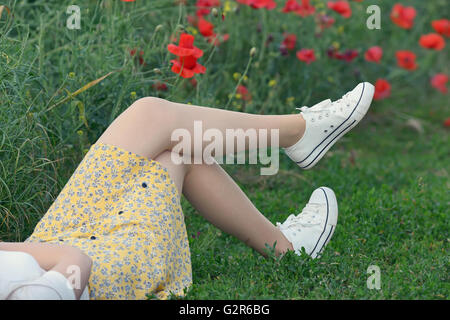 Giovane ragazza distesa sul campo di papavero Foto Stock