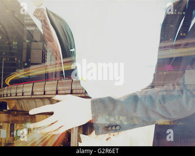 La doppia esposizione di uomini di affari in tuta l'handshaking concordato il partenariato. Foto Stock