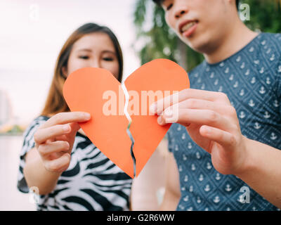 Coppia che cerca di collegare due pezzi di carta cuore - relazione, nel concetto di amore Foto Stock