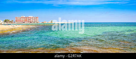 TORREVIEJA, Spagna - 13 settembre 2014: Sunny mediterranean beach, turisti rilassarvi sulla sabbia calda sulle sedie a sdraio sotto gli ombrelloni Foto Stock