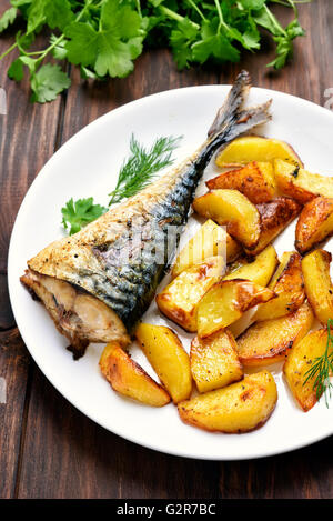 Patate al forno cunei e sgombro pesce sulla piastra Foto Stock