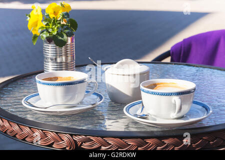 Due tazze di cappuccino stare in piedi sul tavolo di vetro in street cafe foto con messa a fuoco selettiva Foto Stock