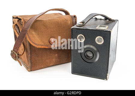 Vintage Box Brownie fotocamera e una tela marrone caso oltre il bianco. Foto Stock