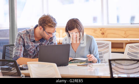 Maschio e femmina partner business lavorano insieme ad un tavolo per conferenza Foto Stock