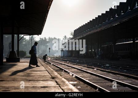 Silhouette di persone in attesa per il treno a Yangon Stazione Ferroviaria Centrale, Myanmar. Foto Stock