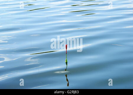 La pesca galleggiante contro blu acque torbide Foto Stock