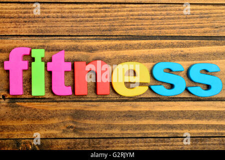 La parola Fitness in un tavolo di legno Foto Stock