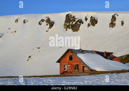 Rovinato ski chalet in montagna innevata di sunrise, il sette Sacri zona dei laghi, montagne Rila, Bulgaria Foto Stock