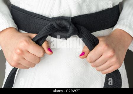 Mani con smalto per unghie di una ragazza con una cintura nera di arti marziali, close up Foto Stock