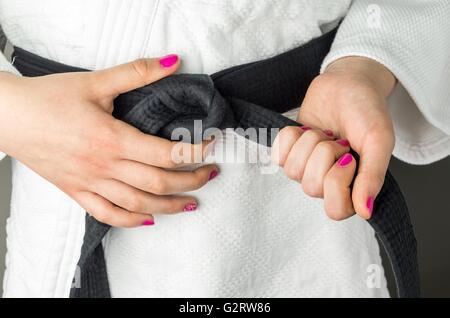 Mani con smalto per unghie di una ragazza con una cintura nera di arti marziali, close up Foto Stock