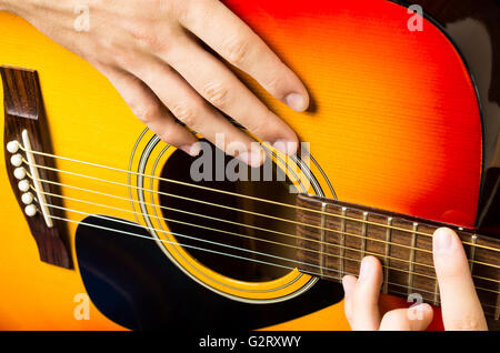 Stretta di mano suonare la chitarra acustica Foto Stock