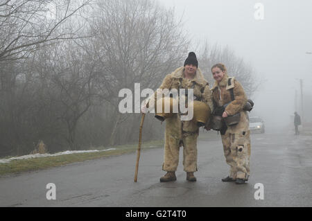 I giovani mascherati come kukers - mummers locale sulla tradizionale celebrazione Surva ogni gennaio nei villaggi vicino a Pernik Foto Stock