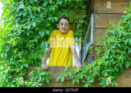 Ragazzo sorridente sul treehouse. L'estate! Foto Stock