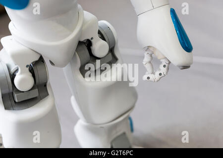 Un piccolo robot con volto umano e corpo - umanoide. Intelligenza artificiale - IA. Robot blu. La mano e le gambe. Foto Stock