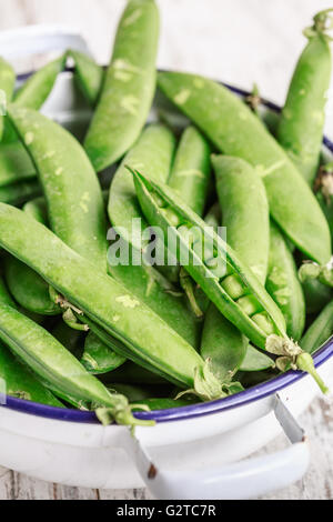 Baccelli di verde i piselli freschi in una ciotola Foto Stock