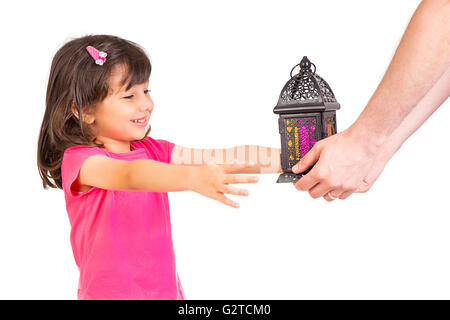 Felice famiglia musulmana in Ramadan - Molto carino bambina sentirsi felice quando il suo papà dando la sua lanterna del Ramadan Foto Stock