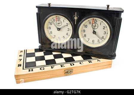 Il vecchio orologio a scacchi sulla scacchiera isolato su bianco Foto Stock