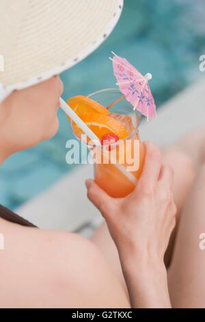 Donna di bere Planter's Punch in piscina Foto Stock