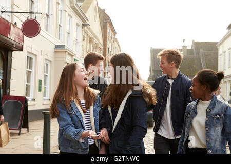 Gruppo di adolescenti a piedi lungo la strada nel contesto urbano Foto Stock