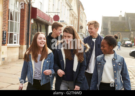 Gruppo di adolescenti a piedi lungo la strada nel contesto urbano Foto Stock