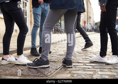 Gruppo di adolescenti in piedi sulla strada nel contesto urbano Foto Stock